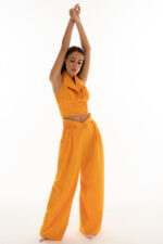 woman wearing high-rise trousers orange color and cropped top with collar