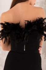 woman wearing black top decorated with feathers